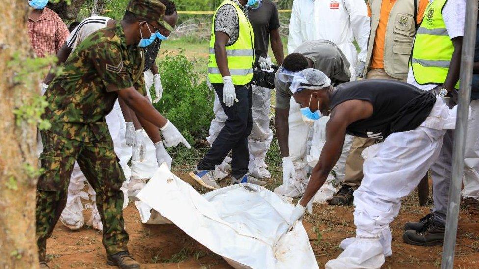 Kenyan homicide detectives and forensic experts from the Directorate of Criminal Investigations (DCI) examine exhumed bodies from several shallow mass graves