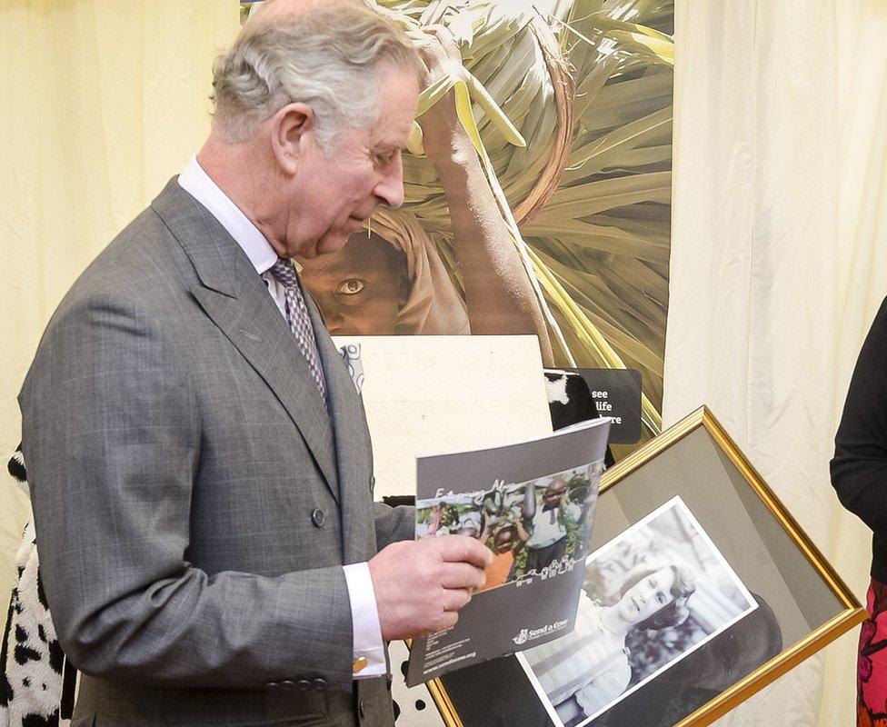 The Prince Of Wales studies the black and white photograph of The Queen