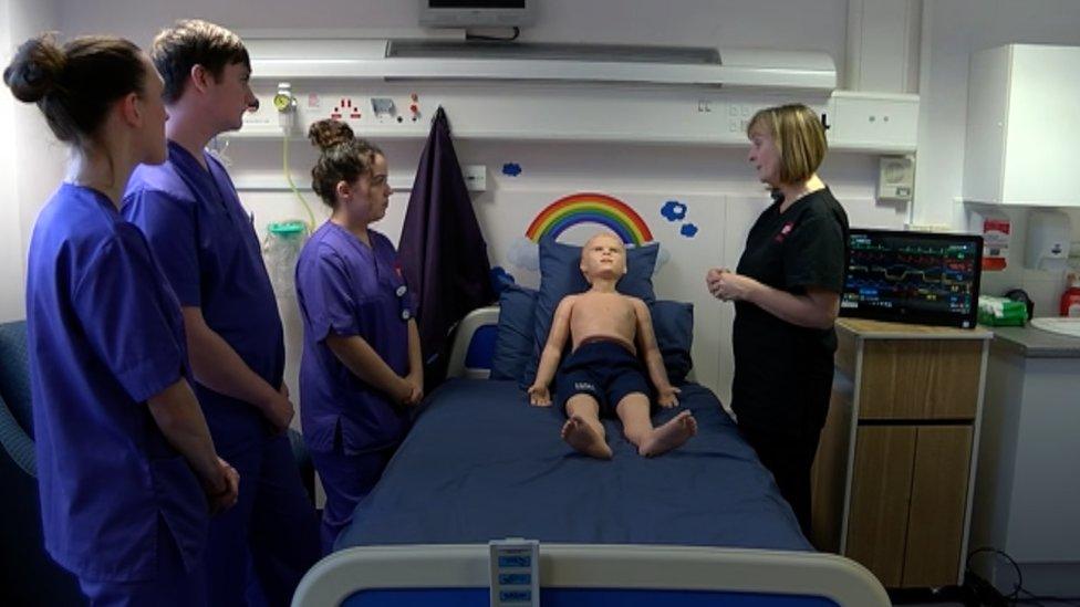 Nurses standing around the manikin