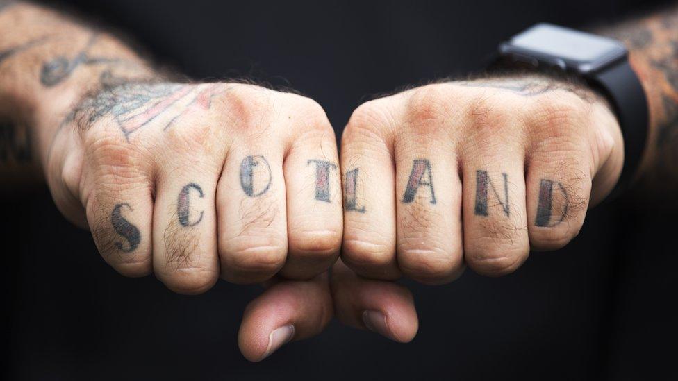 Scotland tattooed across Christian's fingers