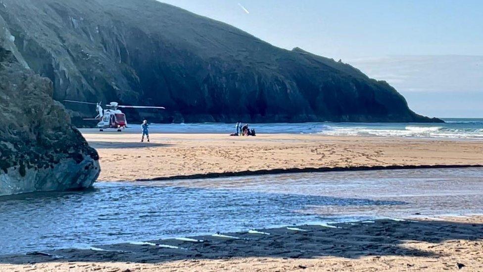 Coastguard helicopter on beach at Holywell Bay