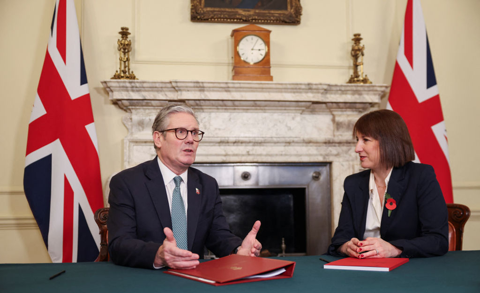 Chancellor Rachel Reeves sitting with Prime Minister Keir Starmer at a table inside Downing Street, on the eve of the Labour government's first Budget