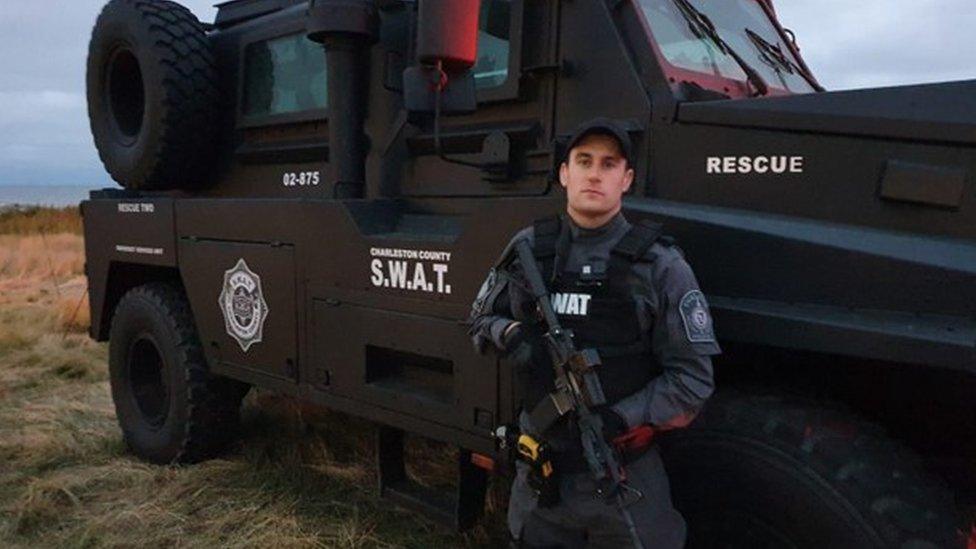 Ryan Adams, in SWAT uniform, stands in front of a SWAT vehicle at Bawdsey