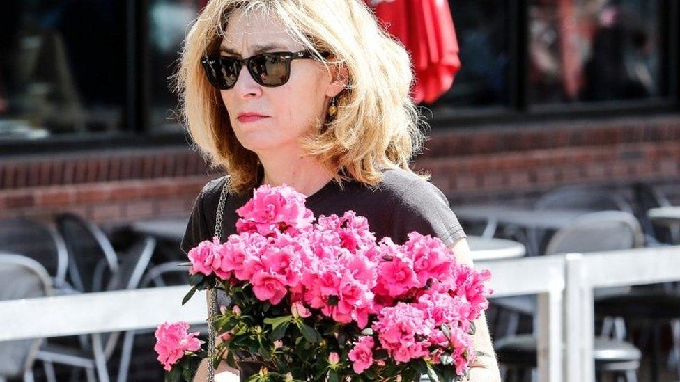 A fan carries flowers as she pays her respects to the late rock "n" roll visionary Chuck Berry at his funeral at The Pageant club in St Louis (09 April 2017)