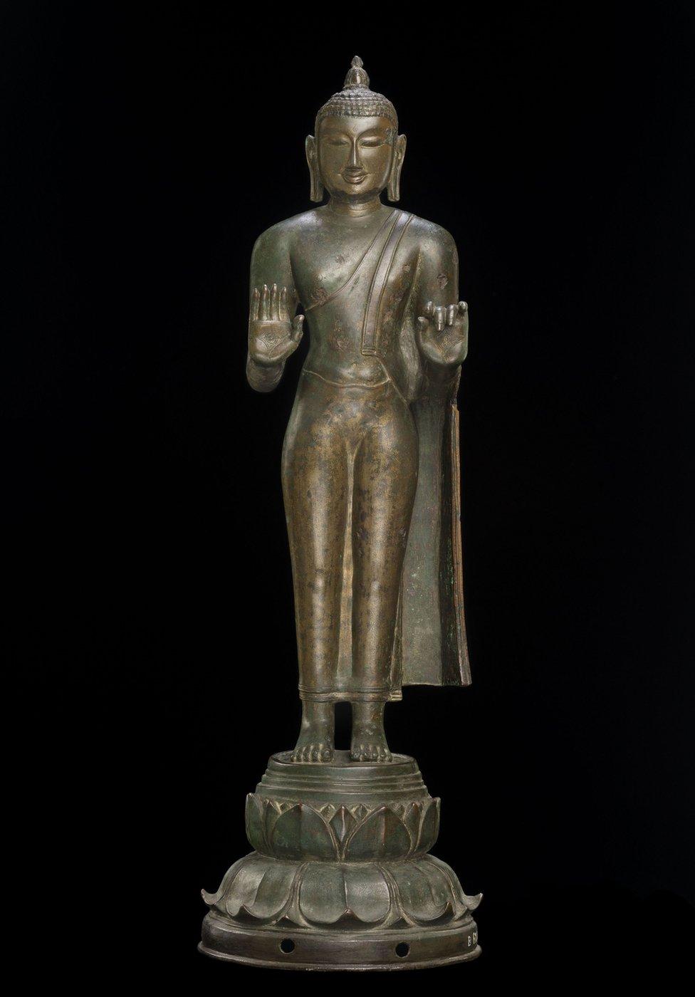 A bronze Buddha statue with a flame on top of the head that symbolises wisdom.