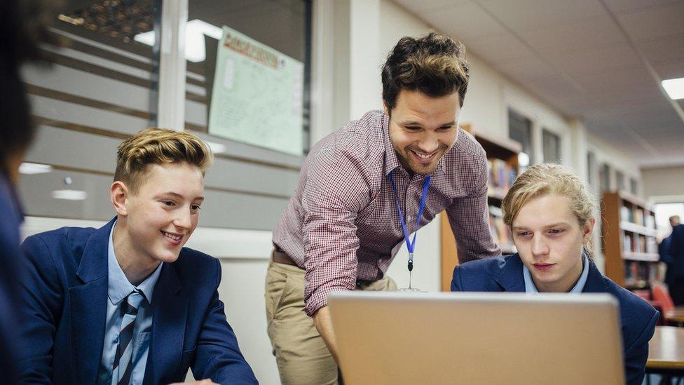 Teacher and pupils looking at laptop