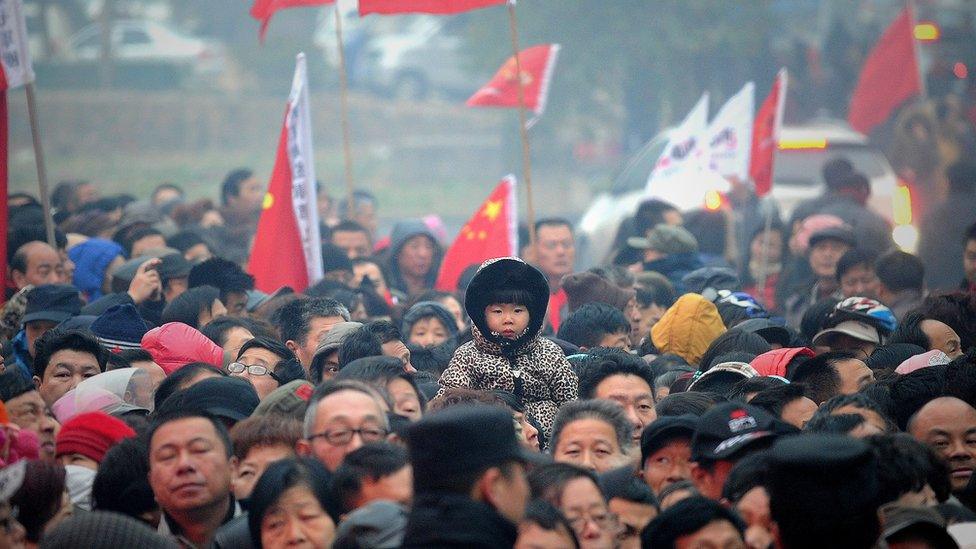 People wait to eat free noodle outside a yard in Shaoshan, in China's central province of Hunan on December 26,2013.