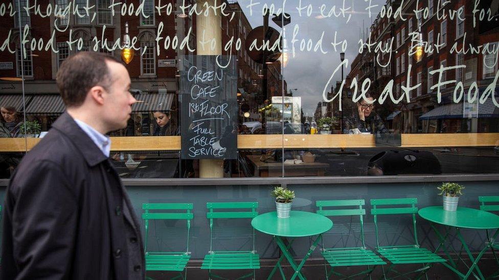 Man walks past cafe