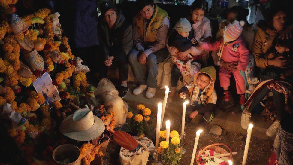 a family is having a picnic in the graveyard to celebrate their relatives