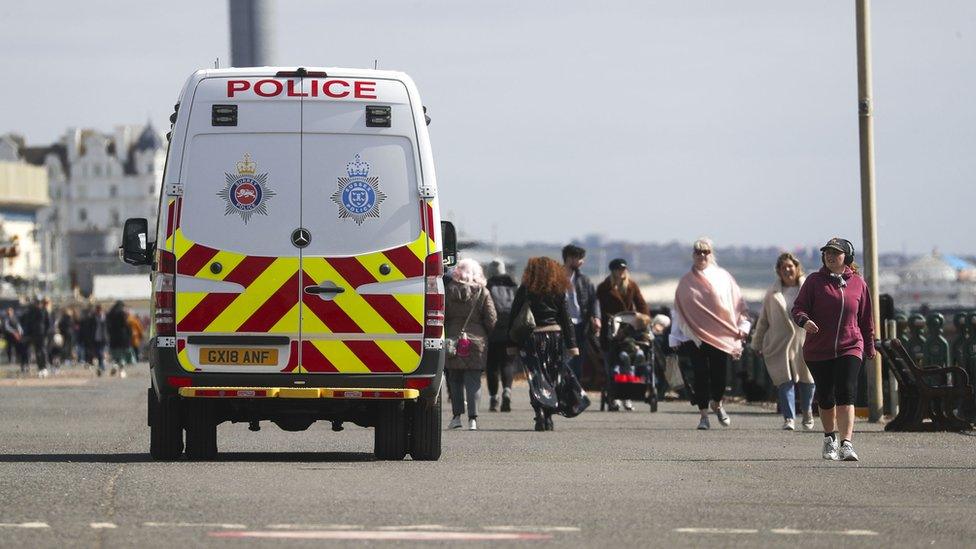 A police van patrols on the promenade next to Brighton Beach, East Sussex.