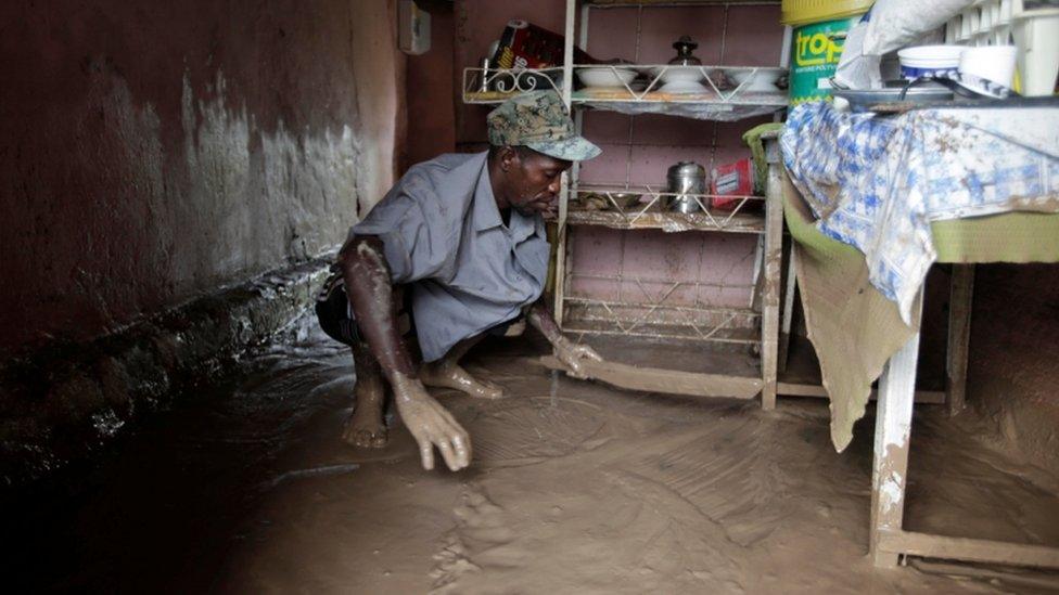 A man clears water from his room in Les Cayes, Haiti, on 5 October 2016