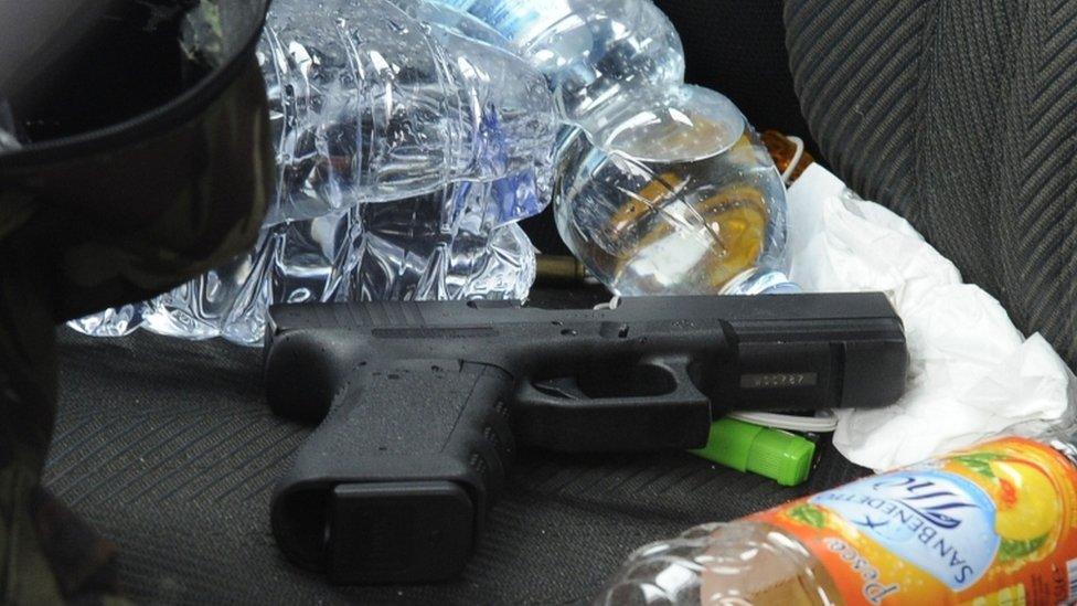 A handgun on the seat of a black Alfa Romeo used by a man suspected of wounding several foreign nationals in a drive-by shooting in Macerata, 3 February