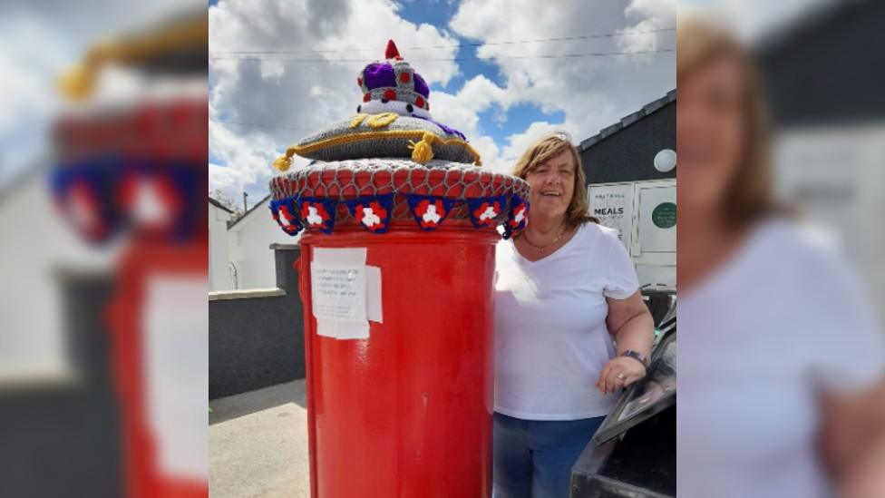 Joy Macdonald stood next to her crochet postbox topper