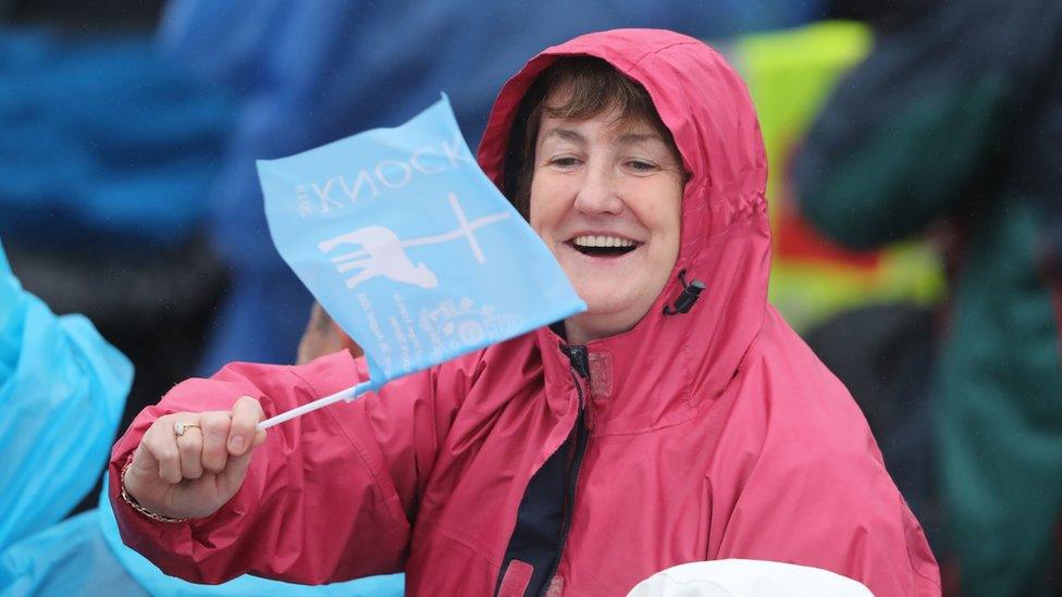 A woman waves a flag at the Knock shrine before the Pope's arrival