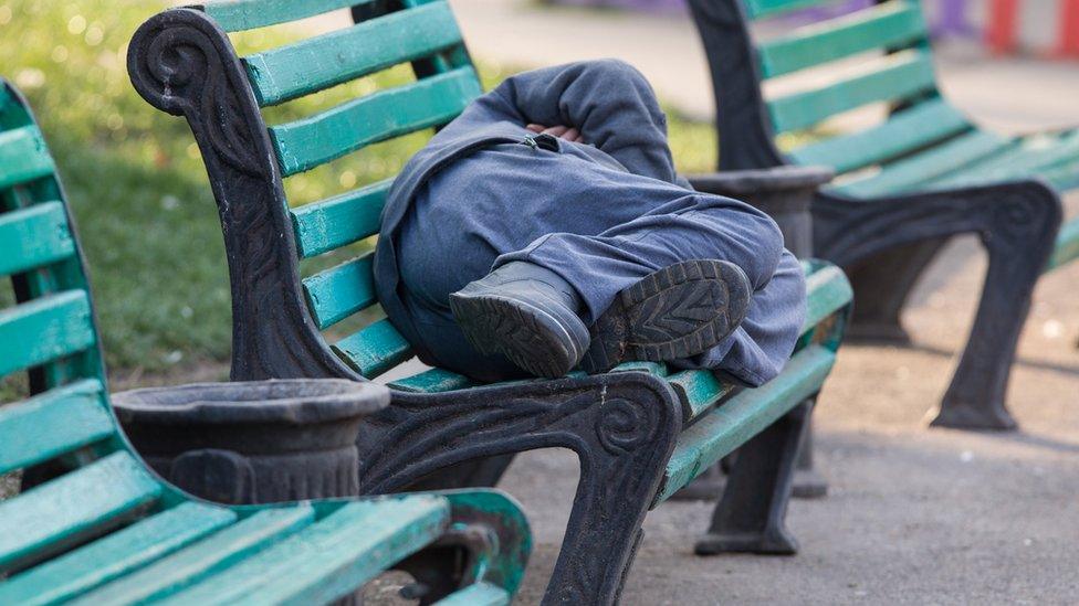 Homeless person on a bench