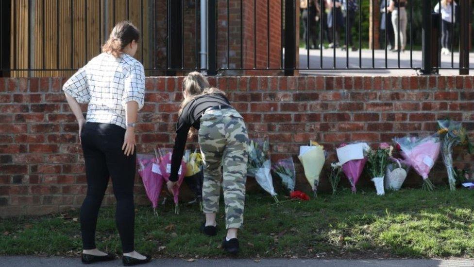 Flowers being placed outside The Holt School