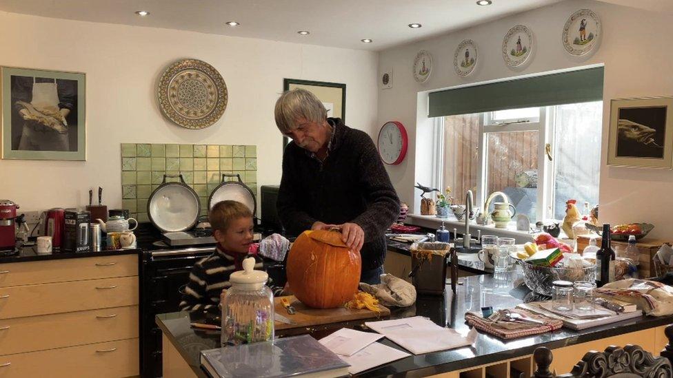 Anastasia's son and Steve carve a pumpkin at Halloween