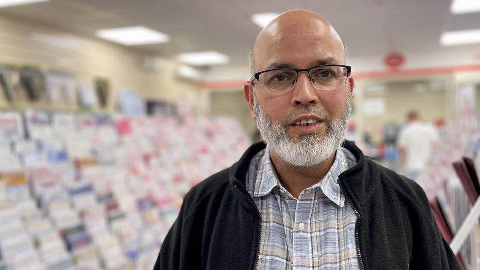 Man in post office looking towards camera