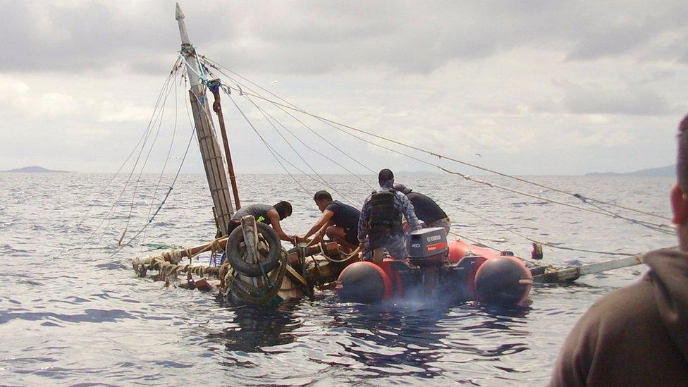 In this photo provided by the Philippine Coast Guard, members of the Philippine Coast Guard inspect the almost sunken fishing boat of Filipino fishermen who were killed by suspected pirates in waters near Zamboanga City, southern Philippines on 10 January 2017.