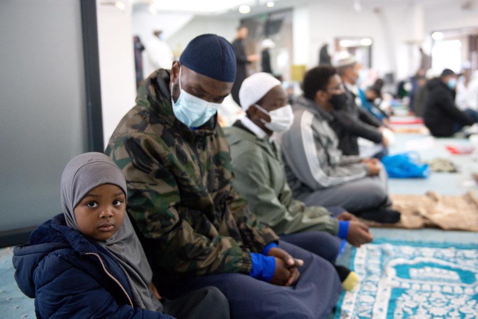 A child prayers with her family at Green Lane Mosque in Birmingham