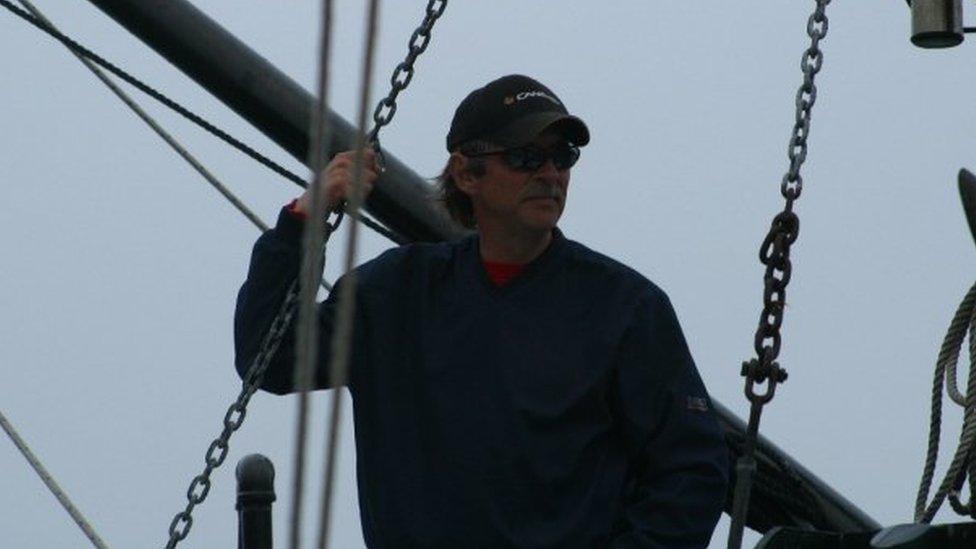 Joseph Howlett pictured aboard a ship, wearing sunglasses and a hat