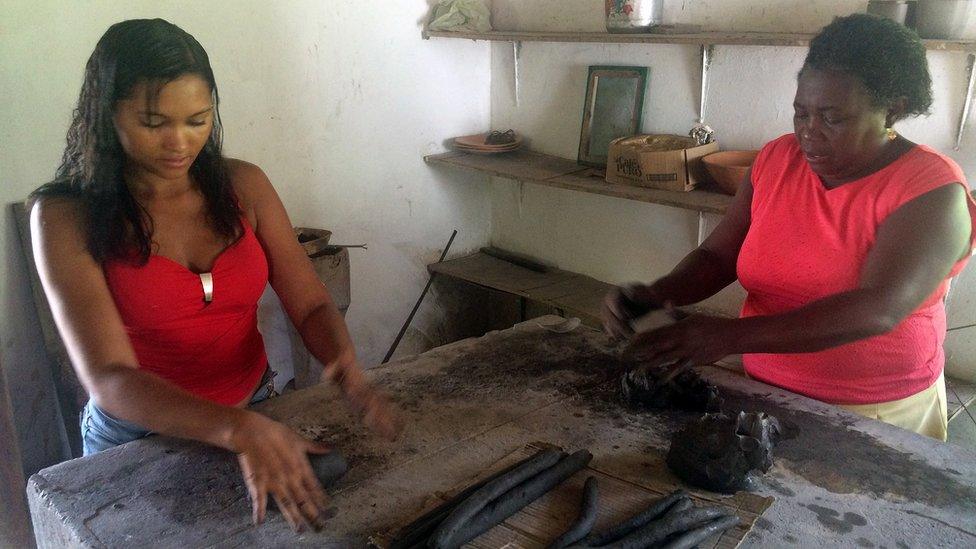 Two women working in the pottery cooperative