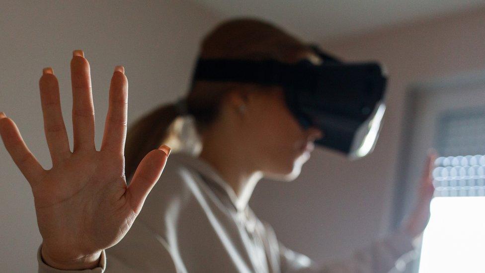 Stock image of a girl, blurred, using a VR headset.