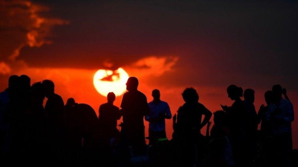 People gather as they wait for the sun to go down and the appearance of the "Blood moon" in Berlin on July 27, 2018. The "Blood moon" total lunar eclipse, is the longest of the 21st century.