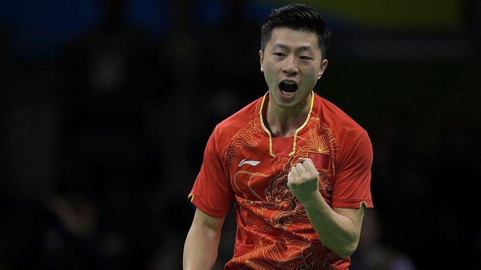 China's Ma Long celebrates after a point against China's Zhang Jike in their men's singles final gold medal table tennis match