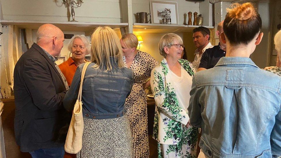 Family members standing and chatting at the bar in The Chapter House, Salisbury