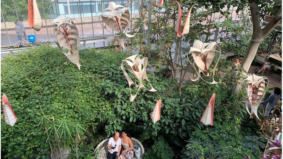 Mini sculptures hanging from ceiling in nature background