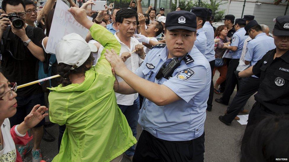 Families of MH370 victims scuffle with police near the Malaysian Embassy in Beijing