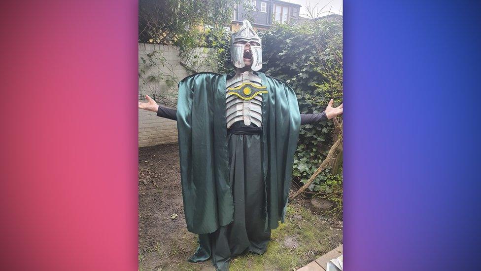 kid pretending to shout into the void while wearing a very accurate looking sauron costume