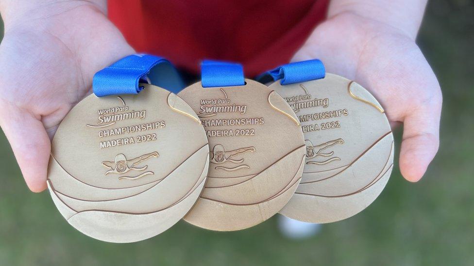 Maisie Summers-Newton holding her 2022 World Championships medals