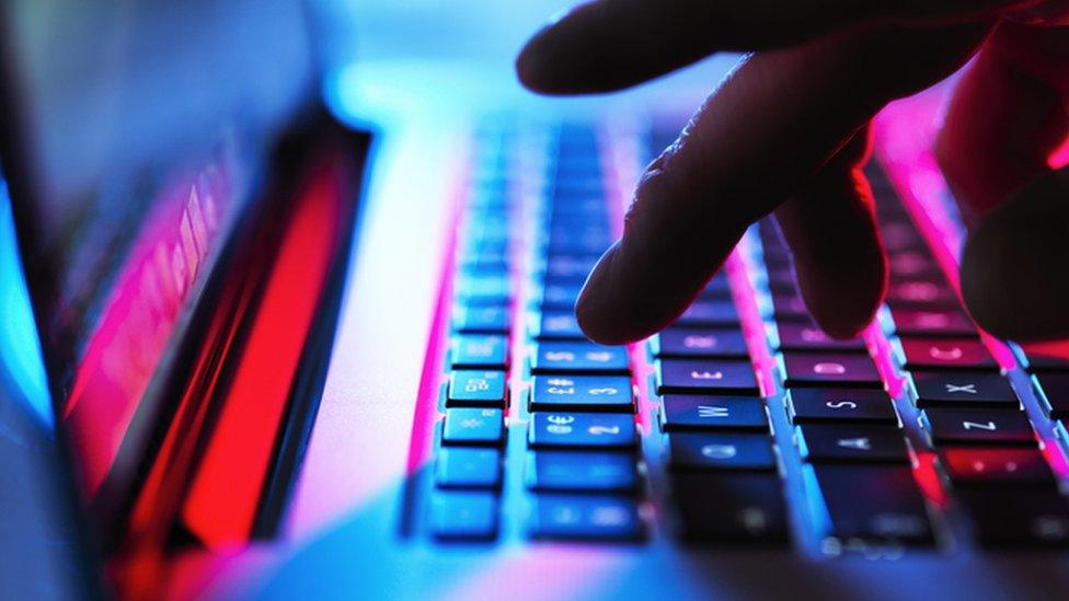 Man typing at his laptop (stock photo)