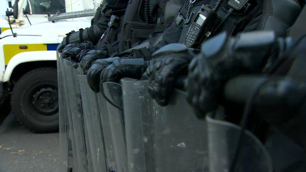 Police officers in riot gear standing in a line