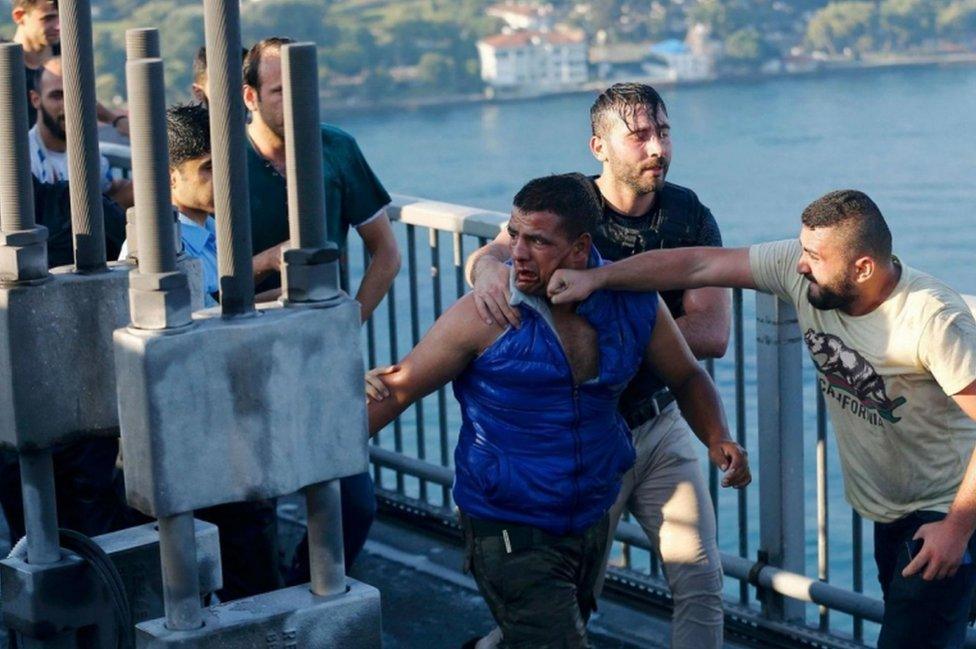 A civilian beats a soldier after troops involved in the coup surrendered on the Bosphorus Bridge in Istanbul, Turkey July 2016