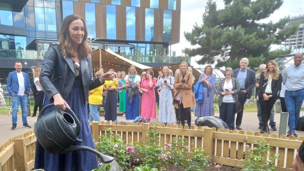 Sally Nugent watering the rose she planted