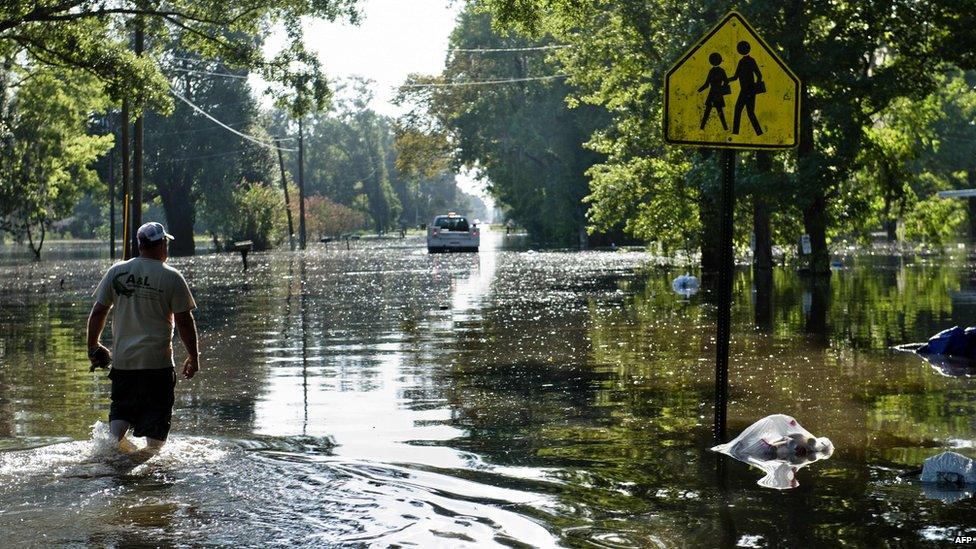 a man stands in flood water