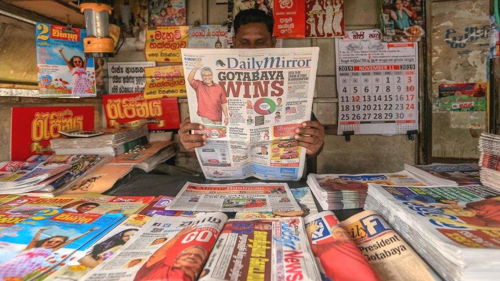 A Sri Lankan man reads a Sri Lankan newspaper headlining the victory of newly elected president Gotabaya Rajapaksa