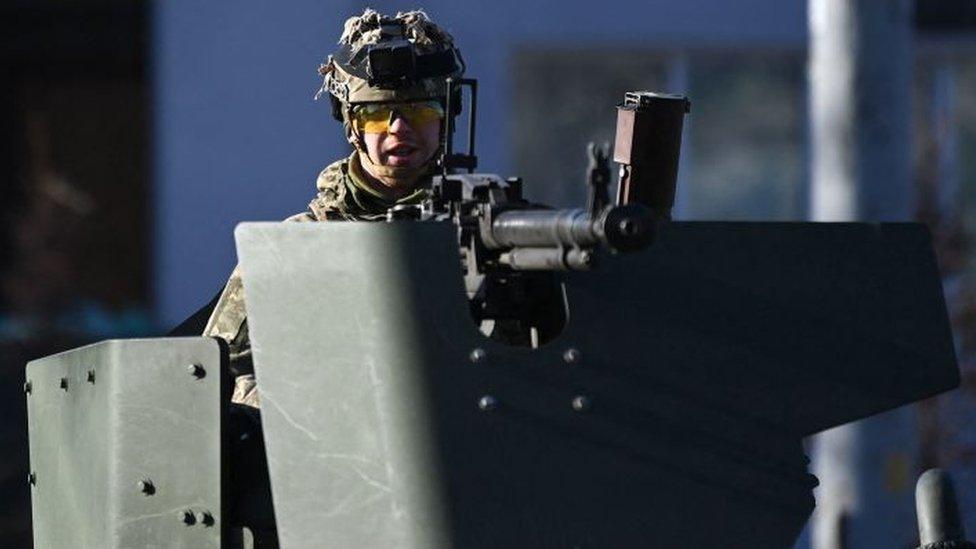 A Ukrainian soldier in an armoured vehicle waits on the west side of the Ukrainian capital of Kyiv.