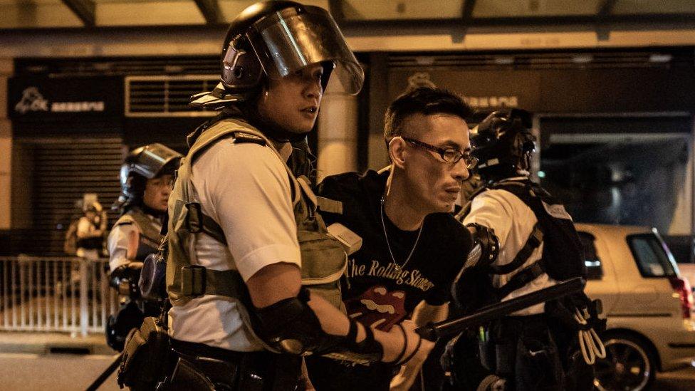 A protester is detained by police outside of Po Lam Station on September 5