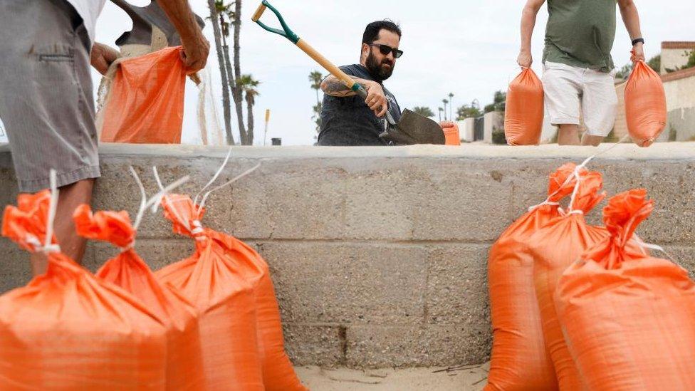 A man with a shovel fills sandbags