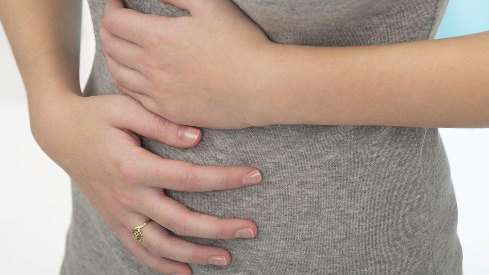 A woman holding her stomach