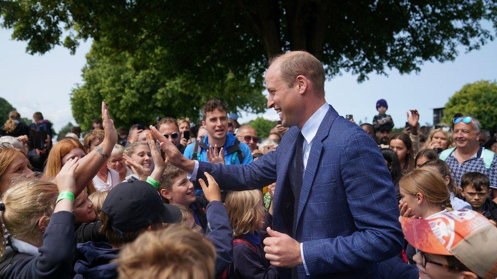 Prince William high fives a group of children from Hingham Primary School