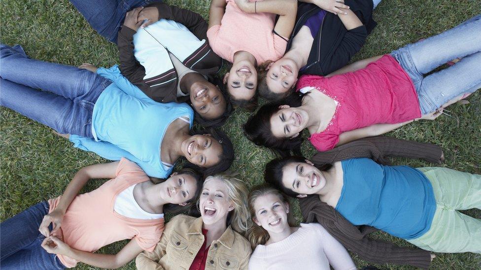 Teenagers lying on some grass