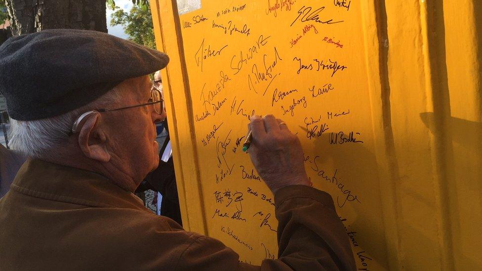 Local resident signing name on phone box