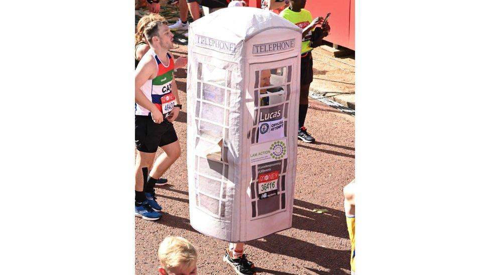 man-runs-in-white-telephone-box-fancy-dress-outfit