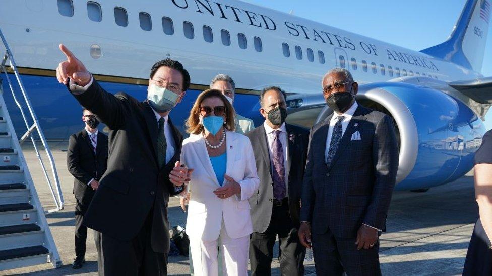 nancy pelosi with her colleagues at an airport leaving taiwan