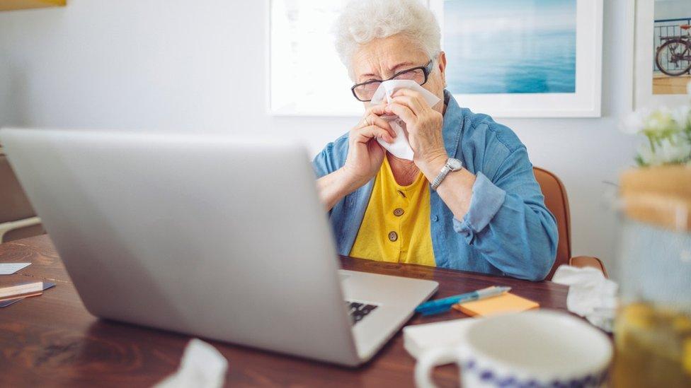 Older woman sitting next to laptop